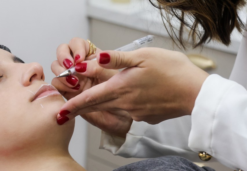 Profissional de estética usando um tablet para planejamento de tratamento.