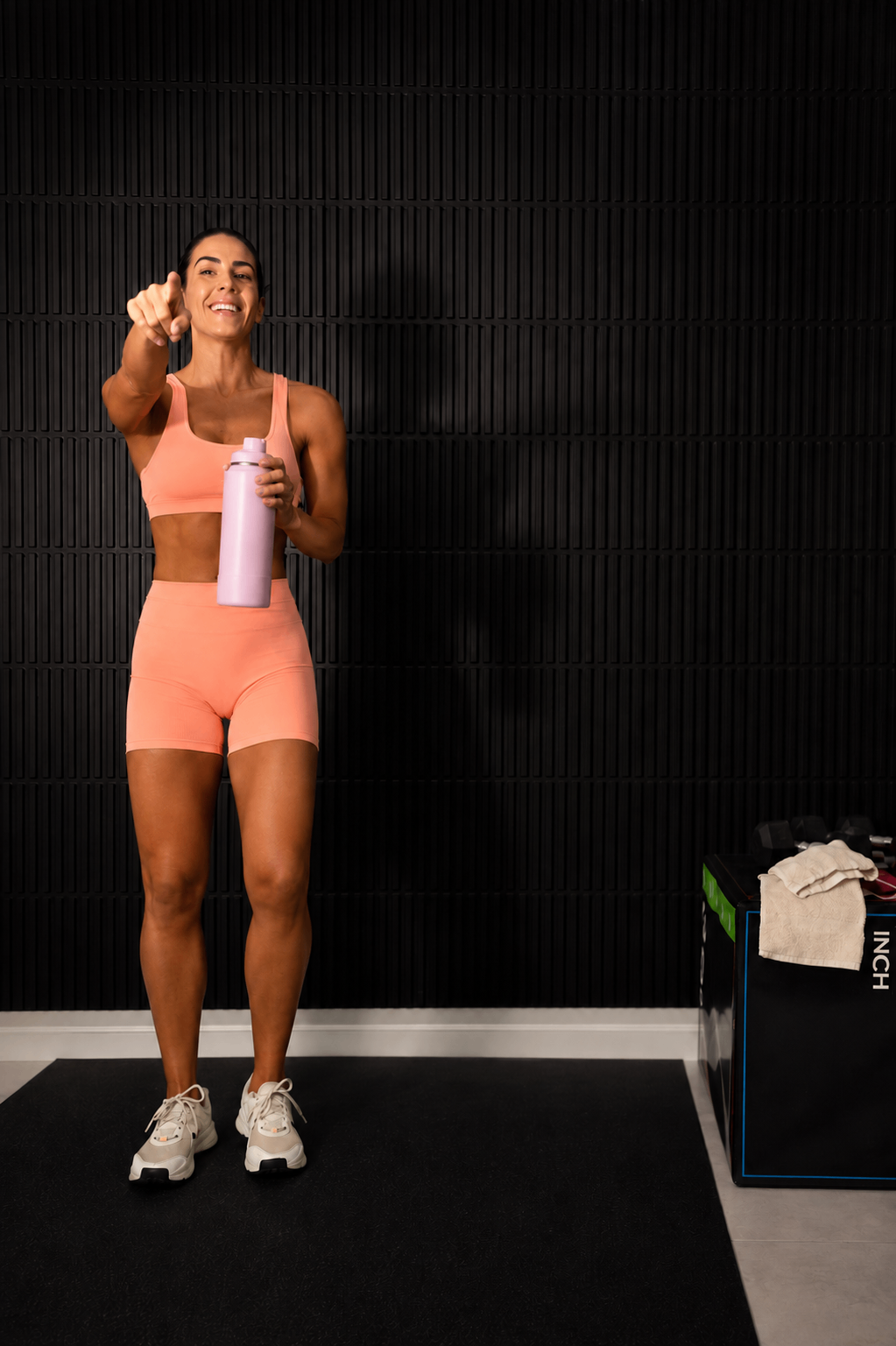 Mujer sonriendo satisfecha con su progreso en el gimnasio