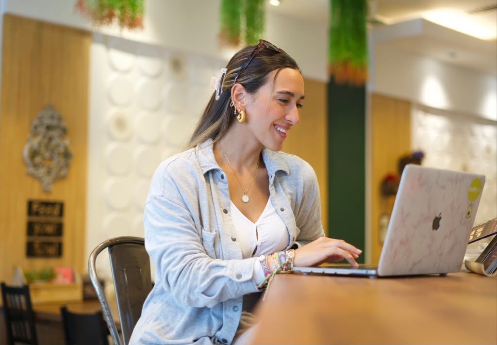 Mari Gutiérrez sonriendo con su laptop