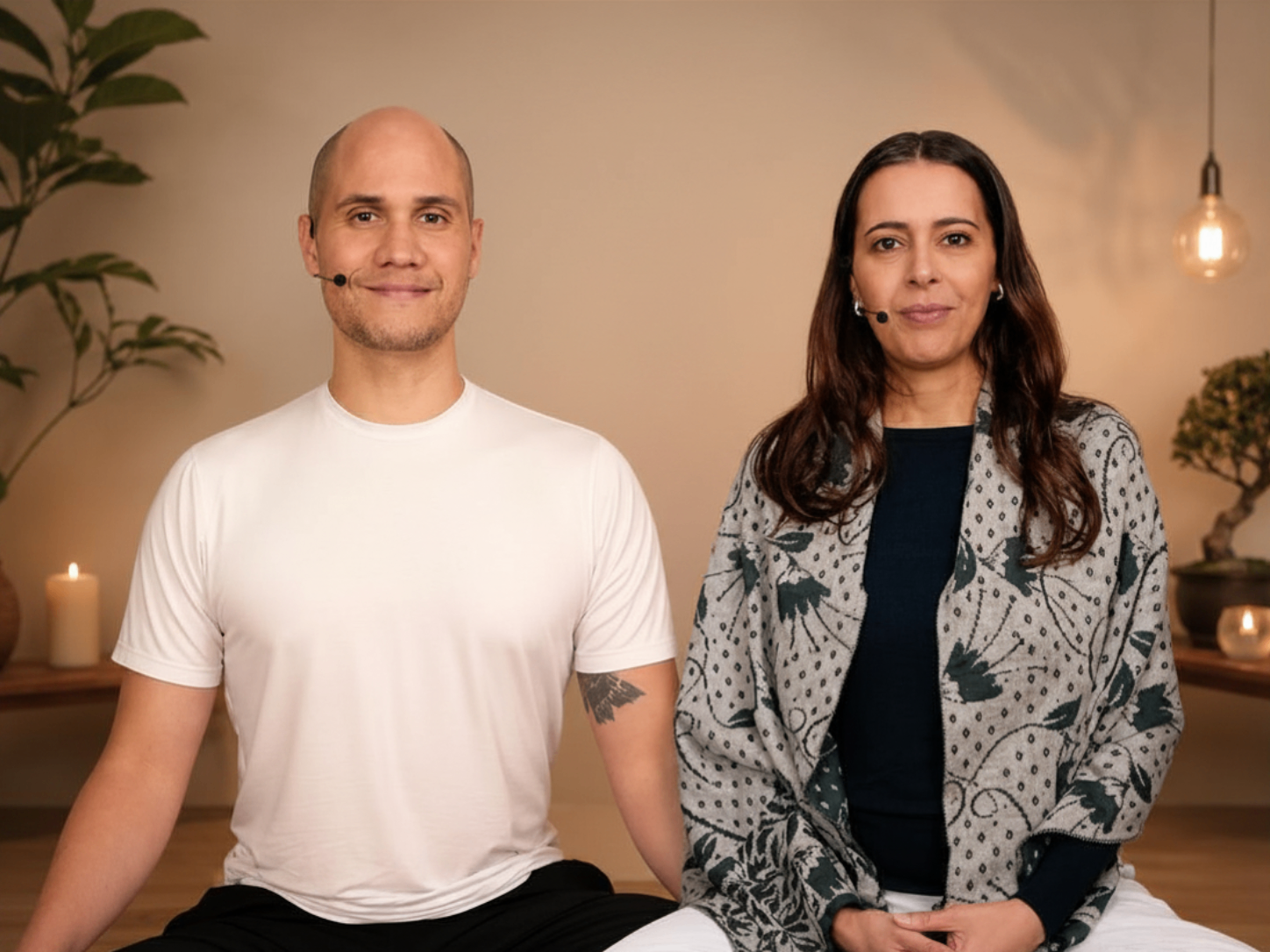 Ricardo Mitra e Luciana Prakash, criadores do curso, sentados em ambiente de meditação acolhedor com luz quente