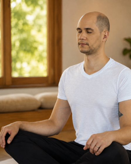 Ricardo Mitra, professor de Yoga e Meditação, meditando em salão de madeira