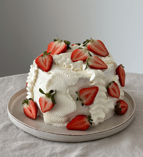 a cake decorated with whipped cream and strawberries