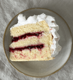 slice of cake with berries compote and whipped cream