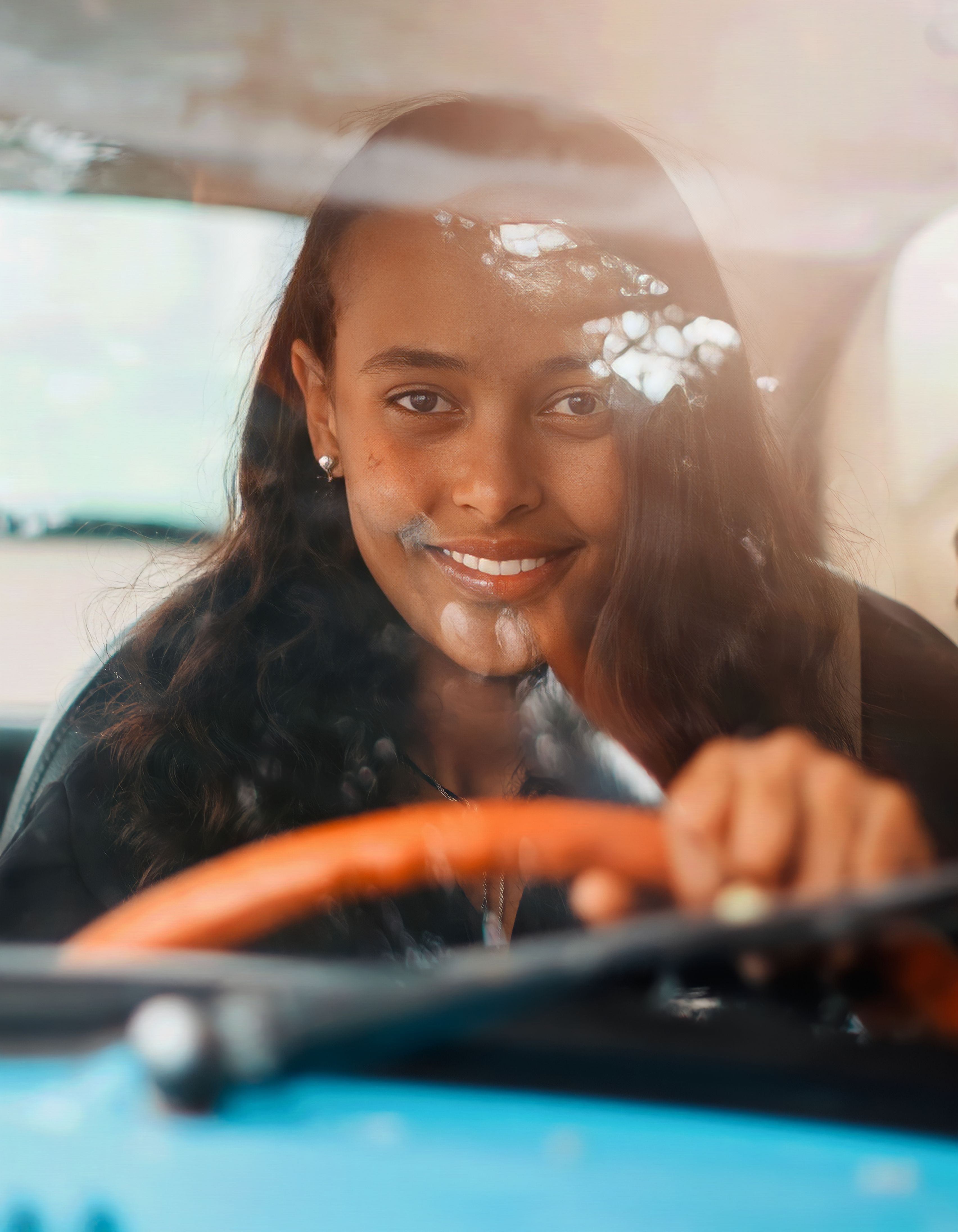 Pessoa sorrindo dirigindo seu carro com segurança